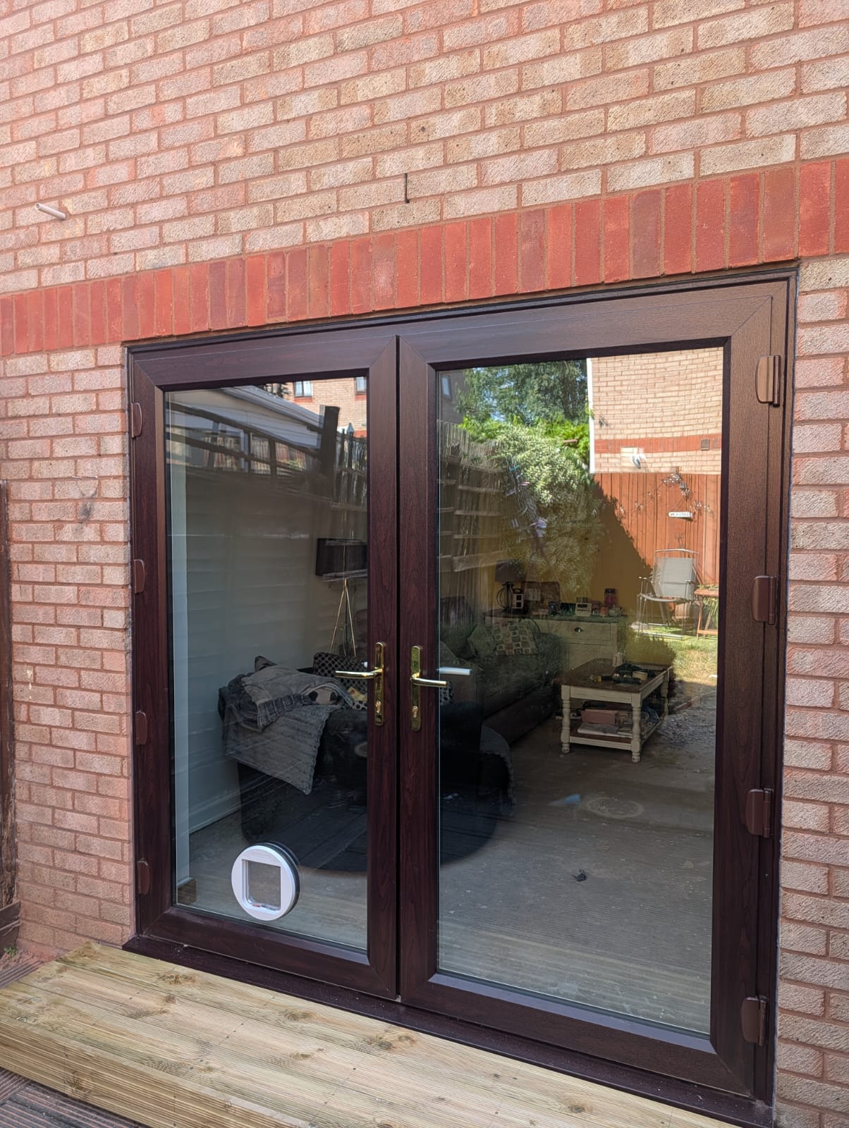 Rosewood UPVC french doors with a cat flap fitted to the glass panel