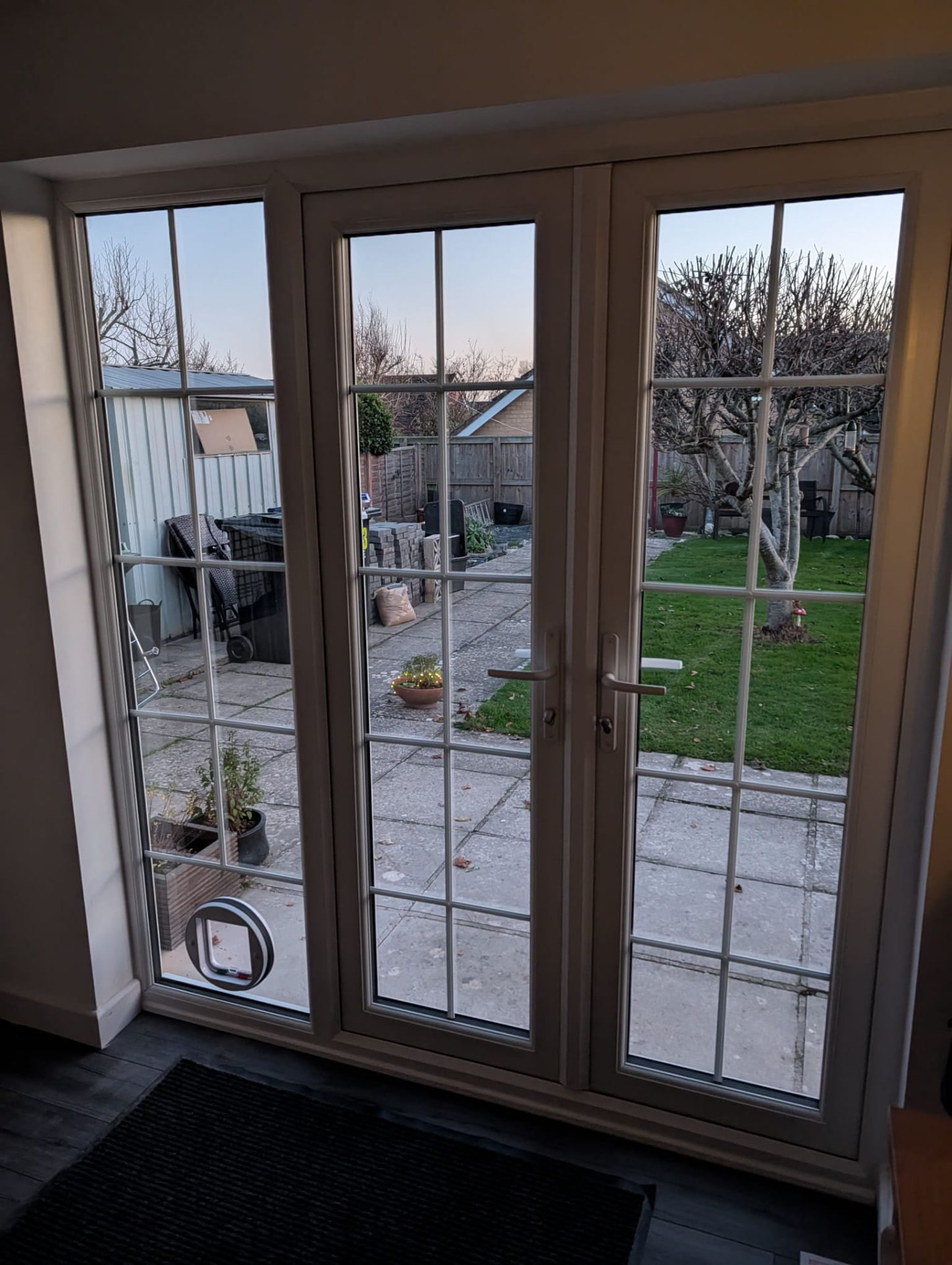 Cream georgian-bar french doors viewed from inside, with cat flap fitted