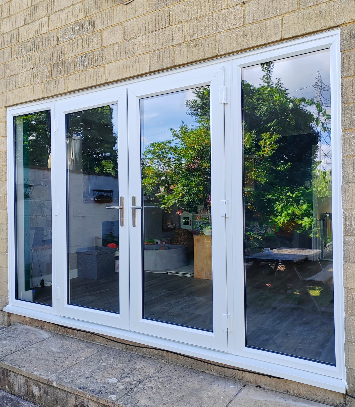 White UPVC french doors with full-height side windows onto a patio